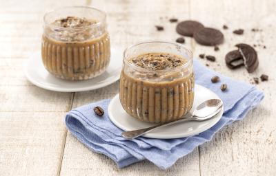 Foto da receita de Palha Italiana de Colher. Observa-se duas taças redondas e transparentes com a palha italiana de colher em um pires branco em cima de um guardanapo azul claro sobre uma superfície de madeira. Atrás, biscoitos NEGRESCO de decoração. Foto da receita de Palha Italiana de Colher. Observa-se duas taças redondas e transparentes com a palha italiana de colher em um pires branco em cima de um guardanapo azul claro sobre uma superfície de madeira. Atrás, biscoitos NEGRESCO de decoração.