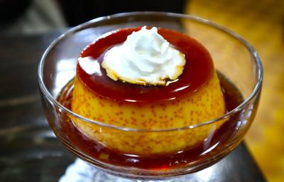 Fotografia de um mini pudim de café dentro de uma taça pequena de vidro com a calda de caramelo. Por cima do pudim tem um pouco de chantilly. Fotografia de um mini pudim de café dentro de uma taça pequena de vidro com a calda de caramelo. Por cima do pudim tem um pouco de chantilly.
