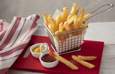 Fotografia em tons de vermelho de uma bancada branca, ao centro uma tábua vermelha com uma cestinha com batatas fritas dentro. Na frente um potinho com ketchup e um com mostarda. Fotografia em tons de vermelho de uma bancada branca, ao centro uma tábua vermelha com uma cestinha com batatas fritas dentro. Na frente um potinho com ketchup e um com mostarda.