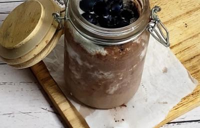 Foto da receita de pudim de chia servida em um pote hermético de vidro sobre uma tábua de madeira em cima de uma mesa de madeira branca. Foto da receita de pudim de chia servida em um pote hermético de vidro sobre uma tábua de madeira em cima de uma mesa de madeira branca.