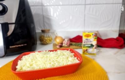 Foto da receita de arroz na airfryer servida em uma travessa vermelha com uma airfryer ao fundo junto com uma embalagem de maggi meu segredo, cebolas e um pano vermelho Foto da receita de arroz na airfryer servida em uma travessa vermelha com uma airfryer ao fundo junto com uma embalagem de maggi meu segredo, cebolas e um pano vermelho