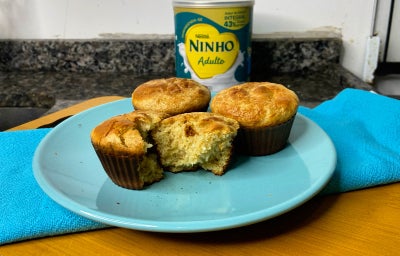 imagem mostra uma cesta cheia de bolinhos em tons dourados e pedaços de coco ralado