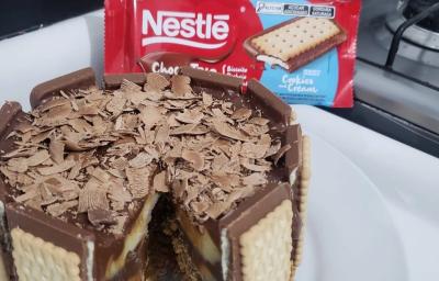 Fotografia de uma torta duo com chocotrio de cookies'n cream com raspas de nestlé classic. A torta está sobre um apoio branco. Fotografia de uma torta duo com chocotrio de cookies'n cream com raspas de nestlé classic. A torta está sobre um apoio branco.