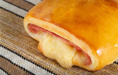 Fotografia de uma receita salgado chamado joelho, recheado com presunto e queijo derretido. Fotografia de uma receita salgado chamado joelho, recheado com presunto e queijo derretido.