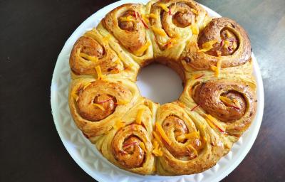 Foto da Receita de Pão de Rosas. Observa-se um pão com formato de rosas brilhante.