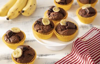 Foto da receita de Muffin de Banana com Chocolate Caribe. Observa-se 8 muffins em forminhas amarelas com uma rodela de banana e metade de um bombom no topo. Foto da receita de Muffin de Banana com Chocolate Caribe. Observa-se 8 muffins em forminhas amarelas com uma rodela de banana e metade de um bombom no topo.
