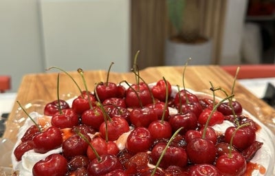 Fotografia de uma Cheesecake de Cereja com Merengue Suíço, decorada com várias cerejas por cima, sobre uma tábua de madeira retangular. Fotografia de uma Cheesecake de Cereja com Merengue Suíço, decorada com várias cerejas por cima, sobre uma tábua de madeira retangular.