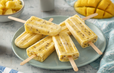 imagem mostra picolé de frutas amarelas com iogurte e Fiber Mais® sabor Laranja, preparado com manga, maracujá e abacaxi.