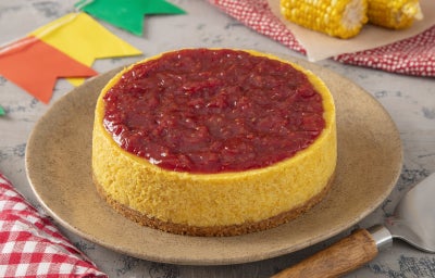 imagem mostra uma torta redonda em tons amarelados e cobertura vermelha
