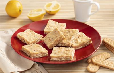 Fotografia em tons de amarelo, vermelho e branco de um paninho listrado amarelo e branco, sobre ele um prato redondo vermelho com palha italiana. Ao lado um paninho branco e biscoitos tostines maizena. Ao fundo uma xícara branca e dois limões. Fotografia em tons de amarelo, vermelho e branco de um paninho listrado amarelo e branco, sobre ele um prato redondo vermelho com palha italiana. Ao lado um paninho branco e biscoitos tostines maizena. Ao fundo uma xícara branca e dois limões.