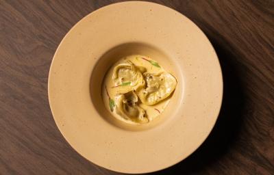 Foto da receita de Ravioli de Escargot feito no Masterchef 11. Observa-se um prato fundo visto de cima com três raviolis servidos com molho e decorado com brotos. Foto da receita de Ravioli de Escargot feito no Masterchef 11. Observa-se um prato fundo visto de cima com três raviolis servidos com molho e decorado com brotos.
