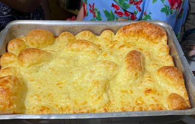 Fotografia de uma forma de alumínio retangular com o pão de queijo montanha russa preenchendo todo o recipiente. Fotografia de uma forma de alumínio retangular com o pão de queijo montanha russa preenchendo todo o recipiente.