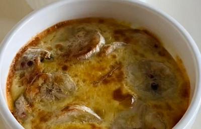 Fotografia de dois ramekins brancos com uma receita de banana cremosa com mel e canela por cima. O ramekin está sobre uma mesa branca. Fotografia de dois ramekins brancos com uma receita de banana cremosa com mel e canela por cima. O ramekin está sobre uma mesa branca.