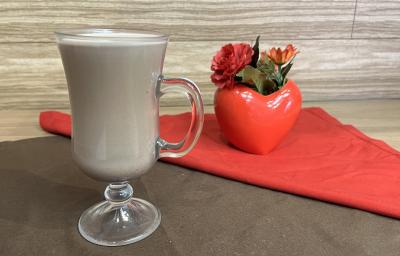 Fotografia em tons de vermelho e marrom com uma caneca de vidro ao centro. Dentro da caneca existe uma receita de Choco-mate Cremoso feito com chá mate e achocolatado NESCAU Extra Cacau 30% Fotografia em tons de vermelho e marrom com uma caneca de vidro ao centro. Dentro da caneca existe uma receita de Choco-mate Cremoso feito com chá mate e achocolatado NESCAU Extra Cacau 30%