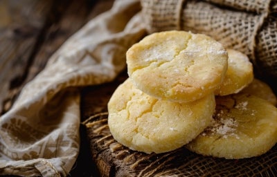 Em cima de uma mesa, prato com biscoitos dourados e crocantes. Em cima de uma mesa, prato com biscoitos dourados e crocantes.