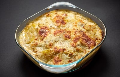 Visto de cima, refratário de vidro transparente com queijo gratinado.