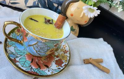 Imagem da receita de GoldenMilk – Bebida Dourada em cima de uma toalha branca e ao lado canelas em pau