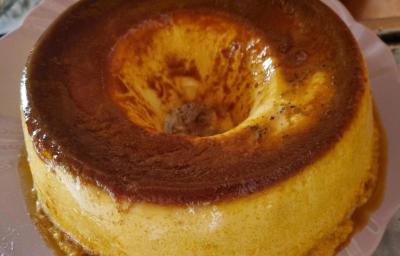 Fotografia de um pudim de maracujá com calda de caramelo de leite escorrendo sobre um apoio branco. Fotografia de um pudim de maracujá com calda de caramelo de leite escorrendo sobre um apoio branco.