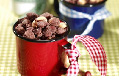 Fotografia em tons de verde, branco e vermelho de uma toalha xadrez verde e branco, sobre ela xícaras com amendoim praline. Fotografia em tons de verde, branco e vermelho de uma toalha xadrez verde e branco, sobre ela xícaras com amendoim praline.