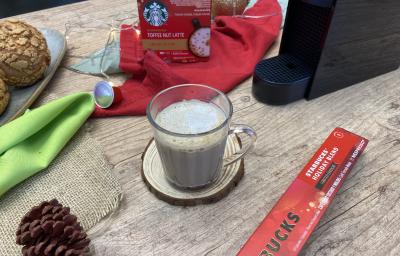 Fotografia em tons de vermelho em uma bancada de madeira com um pano vermelho, uma xícara de vidro com o café e enfeites natalinos. Fotografia em tons de vermelho em uma bancada de madeira com um pano vermelho, uma xícara de vidro com o café e enfeites natalinos.