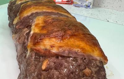 Foto da receita de rocambole de carne moída servida em uma porção grande sobre uma mesa branca Foto da receita de rocambole de carne moída servida em uma porção grande sobre uma mesa branca