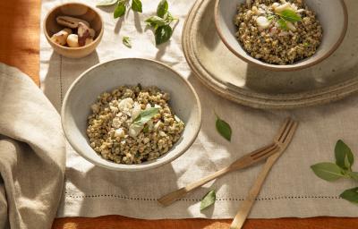 Foto da receita de aveia corte rústico ao pesto servida em duas porções em bowls de cerâmica sobre uma mesa decora com linho