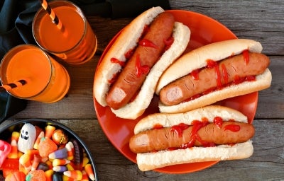 Cachorro-quente com salsichas em formato de dedo, pão macio e dourado, corte superficial na ponta simulando unha, com ketchup vermelho escorrendo. Cachorro-quente com salsichas em formato de dedo, pão macio e dourado, corte superficial na ponta simulando unha, com ketchup vermelho escorrendo.