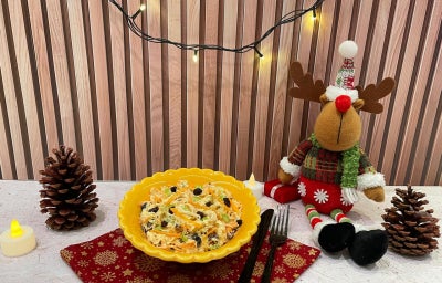 Fotografia em tons de amarelo e natal com um bowl amarelo ao centro e salada de salpicão dentro.