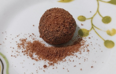 Foto da receita de Brigadeiro de Café. Observa-se um brigadeiro em um prato branco decorado com o café polvilhado por cima. Foto da receita de Brigadeiro de Café. Observa-se um brigadeiro em um prato branco decorado com o café polvilhado por cima.