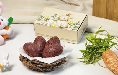 Foto da receita de Mini Ovinho de Páscoa com Ameixa e Mucilon Seleção da Natureza. Observa-se quatro ovinhos de páscoa dentro de uma cesta com decorações de Páscoa no entorno.