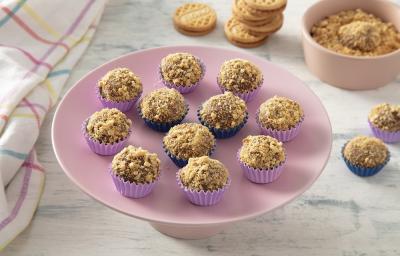 Foto da receita de brigadeiro de doce de leite com biscoito bono servida em diversas porções sobre um prato cor de rosa em cima de uma mesa de madeira cinza com um paninho colorido Foto da receita de brigadeiro de doce de leite com biscoito bono servida em diversas porções sobre um prato cor de rosa em cima de uma mesa de madeira cinza com um paninho colorido