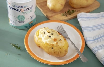 Fotografia batata dourada ao forno, aberta no topo e recheada com creme claro e cremoso, com textura macia e superfície suavemente gratinada.