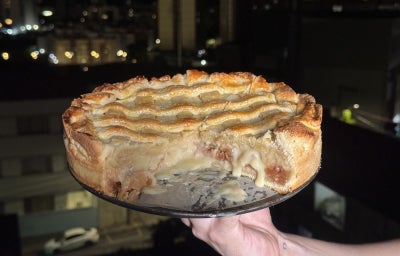 imagem mostra uma torta assada em tons dourados decorada com maças picadas