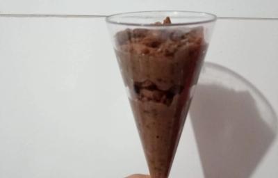Fotografia com uma sobremesa de brigadeiro e biscoito bono chocolate triturado.