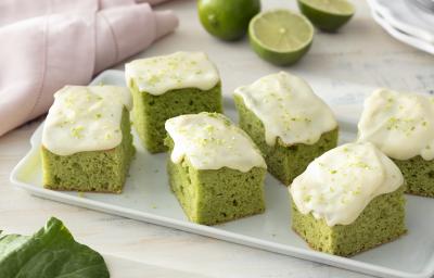 Foto de receita de Bolo de Couve com Calda de Limão. Observa-se uma tábua branca com 6 pedaços de bolo verde com calda de limão. Foto de receita de Bolo de Couve com Calda de Limão. Observa-se uma tábua branca com 6 pedaços de bolo verde com calda de limão.
