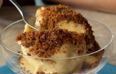 Fotografia de um pote de vidro com sorvete de banana dentro e polvilhado com raspas de chocolate.