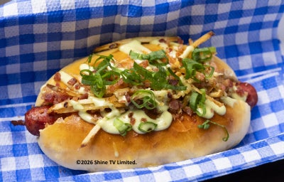 Cachorro-quente gourmet com linguiça artesanal, pão caseiro, maionese verde, batata palha e bacon crocante