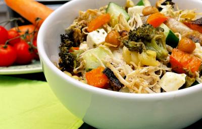 Fotografia em tons de verde com um recipiente fundo ao centro. Dentro do recipiente existe um macarrão com legumes e frango desfiado. Ao fundo existe um ramo de tomate cereja Fotografia em tons de verde com um recipiente fundo ao centro. Dentro do recipiente existe um macarrão com legumes e frango desfiado. Ao fundo existe um ramo de tomate cereja