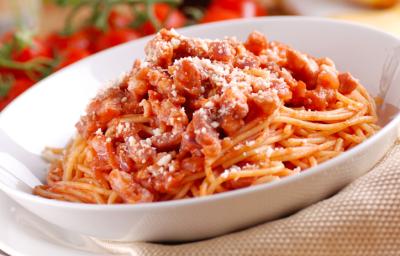 sobre um prato branco, uma porção de macarrão com molho de tomates pedaçudos e queijo ralado. sobre um prato branco, uma porção de macarrão com molho de tomates pedaçudos e queijo ralado.