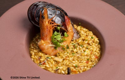 Paella de frutos do mar com camarão, mexilhão e arroz cremoso, finalizada com brotos