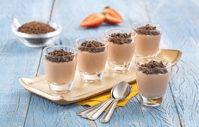 Foto de Receita de Brigadeiro de Morango com Nibs de Cacau. Observa-se uma peça de cerâmica retangular com cinco copinhos de vidro transparentes sob uma madeira azul clara. Foto de Receita de Brigadeiro de Morango com Nibs de Cacau. Observa-se uma peça de cerâmica retangular com cinco copinhos de vidro transparentes sob uma madeira azul clara.