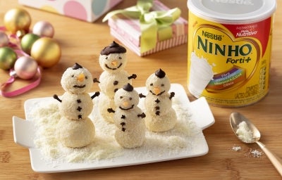 Fotografia em tons claros com vários bonecos de neve feitos com brigadeiro de NINHO