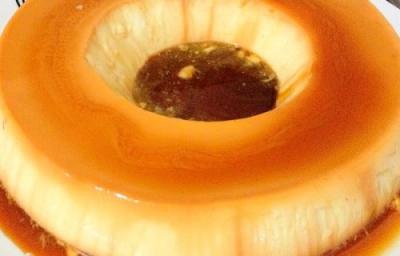 Foto em tons de caramelo da receita de pudim de leite em pó servida em uma porção inteira Foto em tons de caramelo da receita de pudim de leite em pó servida em uma porção inteira