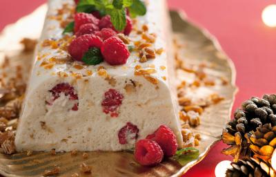 uma mesa rosa contém uma travessinha dourada com o semifredo decorado com frutas vermelhas