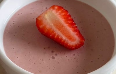 Fotografia de três ramekins brancos com mousse de morango e metade de um morango por cima, decorando cada um. Fotografia de três ramekins brancos com mousse de morango e metade de um morango por cima, decorando cada um.