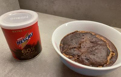 Receita de Baked Oats, em um recipiente branco, sobre uma mesa e ao lado o Nescau 60% Cacau