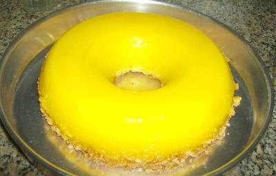 Fotografia de uma receita de quindim grande dentro de uma forma meio funda prata. Fotografia de uma receita de quindim grande dentro de uma forma meio funda prata.