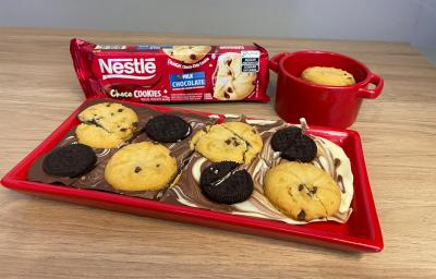 Fotografia de uma barra de chocolate mesclada com chocolate branco, sobre ela uma mistura de biscoitos e cookies. Fotografia de uma barra de chocolate mesclada com chocolate branco, sobre ela uma mistura de biscoitos e cookies.