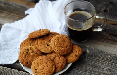 Em cima de uma mesa, prato com biscoitos em redondos crocantes e dourados. Em cima de uma mesa, prato com biscoitos em redondos crocantes e dourados.