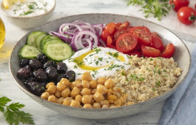 imagem mostra bowl mediterrâneo com quinoa, grão-de-bico, tomate-cereja, pepino, cebola roxa e azeitonas pretas, servido com molho de iogurte e Fiber Mais® Limão + Colágeno.